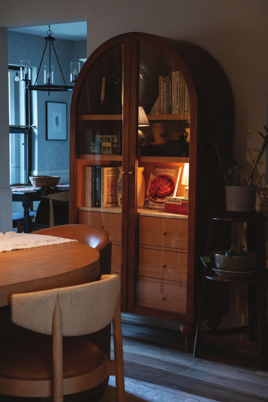 An arched wood display cabinet in a dining room