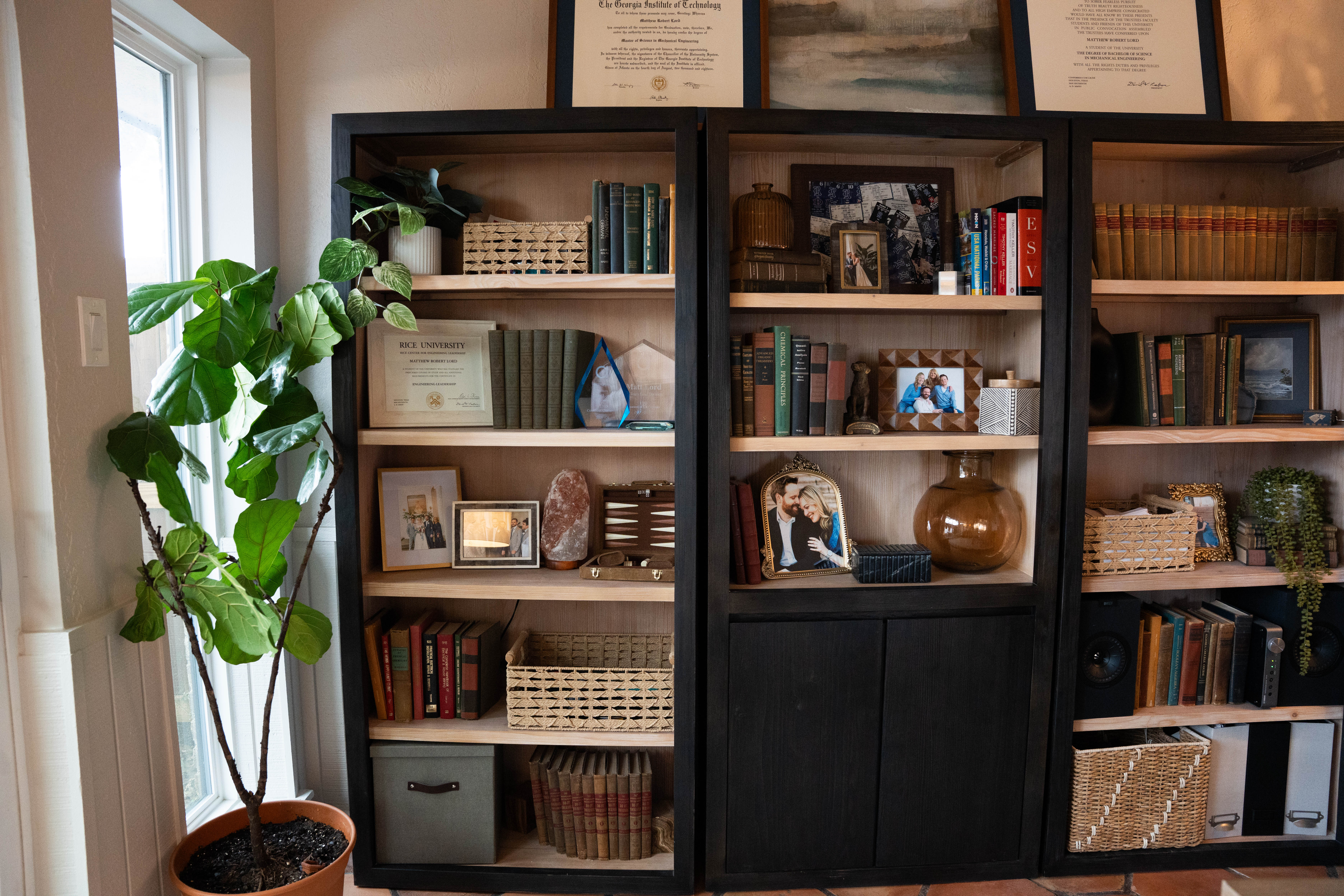 A lamplit console table with a carved wood vase
