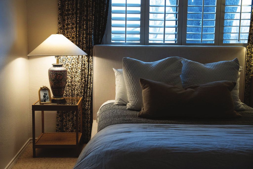 Bedroom with floral drapes and a ginger jar lamp